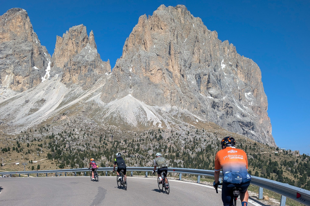 Cyclists riding beneath Dolomite peaks