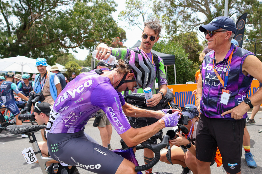 Professional rider cooling down after a Tour Down Under stage while interacting with team staff