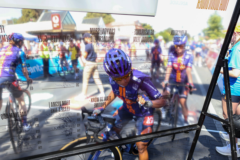 Professional cyclist signing a presentation board at the Tour Down Under