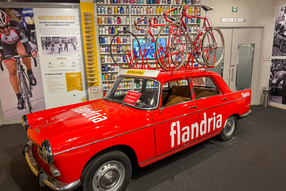 Vintage red Flandria team car displayed at a cycling museum in Belgium.