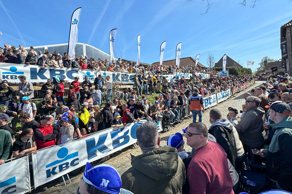 Large crowds watching the Tour of Flanders from a cobbled climb in Belgium.